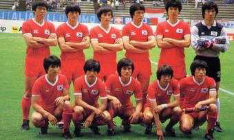 1986년 멕시코 월드컵에 출전한 대한민국 축구 국가대표팀 선수들이 경기 전 경기장 내에서 단체 사진을 촬영하고 있는 모습. 전원 붉은색 유니폼을 착용하고 있으며, 뒷줄은 팔짱을 끼고 서 있고 앞줄은 무릎을 꿇고 앉아 있다.